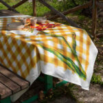 tovaglia di lino a scacchi gialli con un fiore rosso