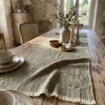 Runner da tavola Intersezioni verde in tessuto jacquard di canapa e cotone su tavolo rustico